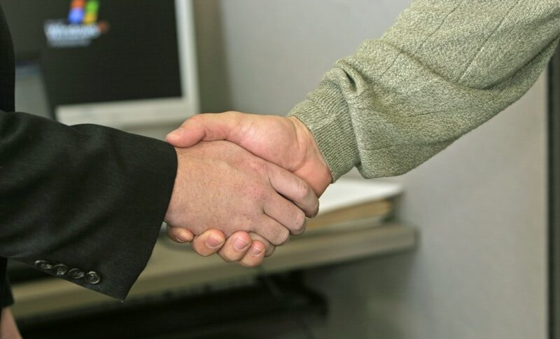 Professionals shaking hands after closing business acquisition